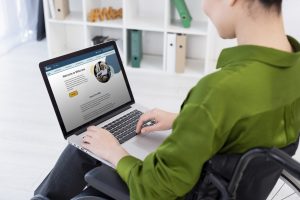 person in wheelchair using laptop